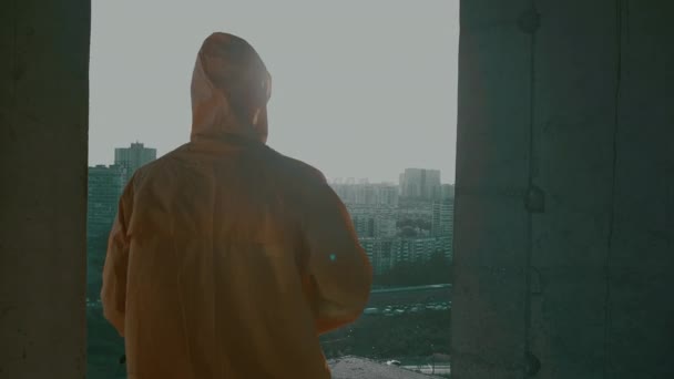 Man in beschermend pak, gasmasker met machinegeweer kijkt van hoogte naar de zijkanten — Stockvideo
