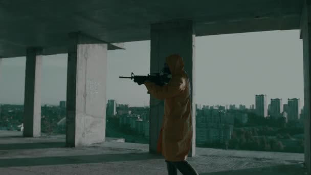 Людина в захисному костюмі, газова маска, зі зброєю проходить через незакінчений офіс — стокове відео