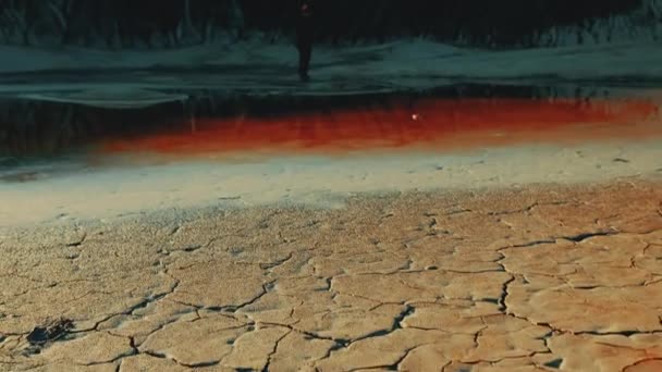 Mann geht durch menschenleeres Gebiet, vor Felshintergrund, ähnelt Mars. — Stockvideo