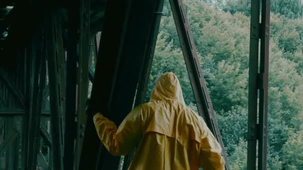 Man skyddsdräkt, gasmask går över en järnbro. Utsikt från baksidan. — Stockvideo
