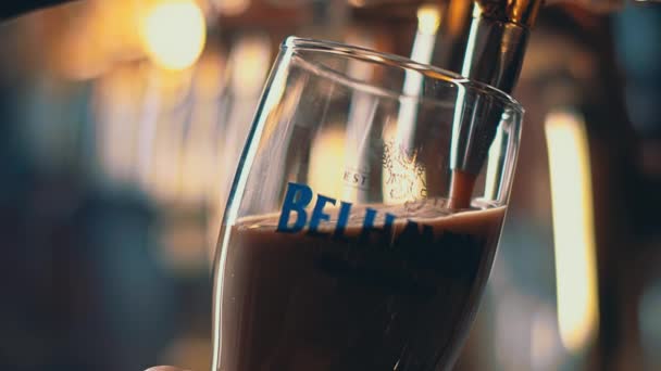 La bière noire est versée dans un verre à ras bord, les mousses de bière. pub de bière. — Video