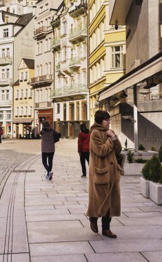 Karlovy Vary, Çek Cumhuriyeti - 8 Mart 2021 Kürklü, şık bir kadın giyim mağazalarının camlarına bakıyor