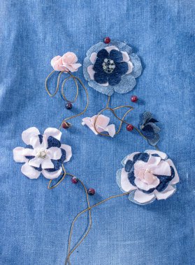 Eski kot pantolonlardan ve pembe formalardan çiçekler. Dekorasyon ya da geri dönüşüm kotu. Nesnelerin yeniden kullanımı ve doğal kaynakların korunması kavramı.