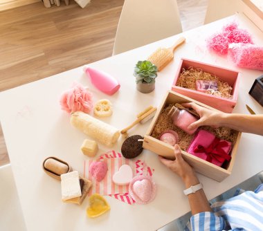 Genç bir kadın hediye paketi, doğal spa seti, kadınlar ya da anneler günü ve sevgililer günü için dekoratif saksı olan banyo malzemeleri. Kadınlar için organik vücut bakımı hediyesi kavramı.