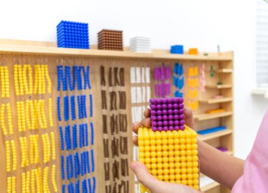 Çizgili kız, Montessori okulunda renkli plastik geometrik şekiller bulmacası çözüyor. Matematiksel geometri kullanma kavramı kaynakları öğrenme çocuk eğitimi.