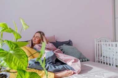 Genç kadın rahat yumuşak bir yatakta oturarak uyandı. Ev refahı. Refah kavramı.