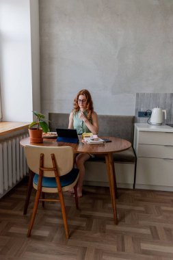 Defoktus. Genç bir kadın öğle yemeği sırasında bilgisayarla eğitimini internetten alıyor. Serbest çalışan bir kadın dizüstü bilgisayarda geziniyor. Aşırı bilgi yüklenmesi kavramı. Teknoloji ve insanlar. Evde Konfor Bölgesi.