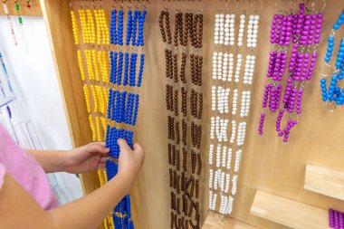 Çizgili kız, Montessori okulunda renkli plastik geometrik şekiller bulmacası çözüyor. Matematiksel geometri kullanma kavramı kaynakları öğrenme çocuk eğitimi.