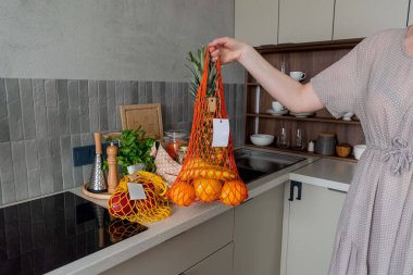 Mutfak masasında poşet dolusu erzak. Sebze ve meyveli ip torbası alışverişi. Bilinçli tüketim. Sıfır atık. Cam kavanozlarda gevrekler.