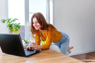 Defoktus. Genç bir kadın internette bilgisayar kullanarak psikoterapi görüyor. Kız dizüstü bilgisayara bakıyor. İnsanların sağlığı ve akıl sağlığı kavramı. Evde konfor bölgesi var..