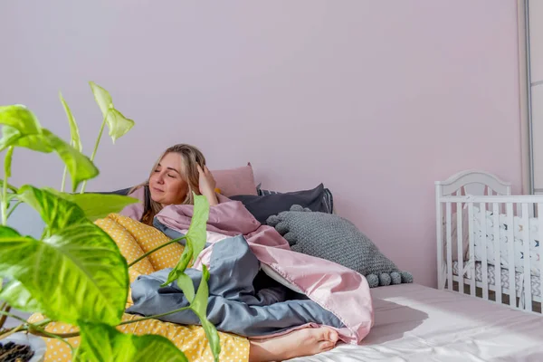 Genç kadın rahat yumuşak bir yatakta oturarak uyandı. Ev refahı. Refah kavramı.