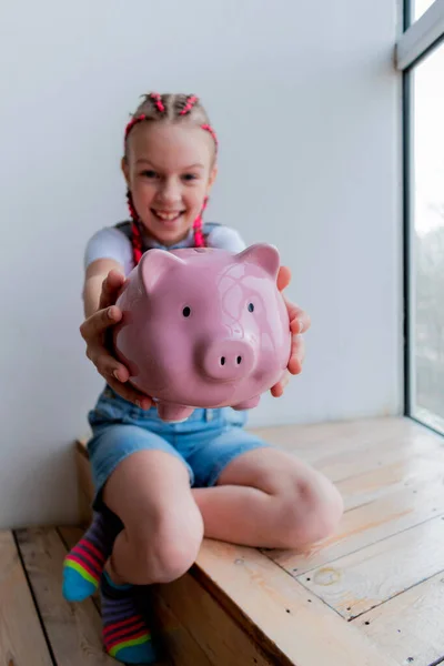 Teenage girl learns financial literacy. Child saving money in piggy bank. Future business planning concept.