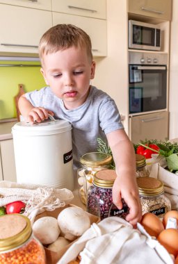 Çocuk bir fındık için bez torbaya uzanıyor. Uzayı kopyala Vejetaryen alışverişi. Sıfır atık. Plastik yok.