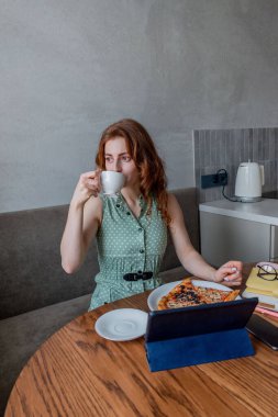 Defoktus. Genç bir kadın öğle yemeği sırasında bilgisayarla eğitimini internetten alıyor. Serbest çalışan bir kadın dizüstü bilgisayarda geziniyor. Aşırı bilgi yüklenmesi kavramı. Teknoloji ve insanlar. Evde Konfor Bölgesi.