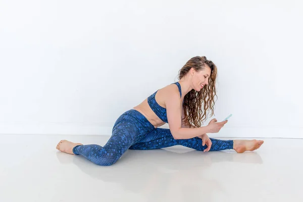 Ung Mångsidig Kvinna Tar Hjälp Mobiltelefoner Gör Yoga Sitter Golvet — Stockfoto