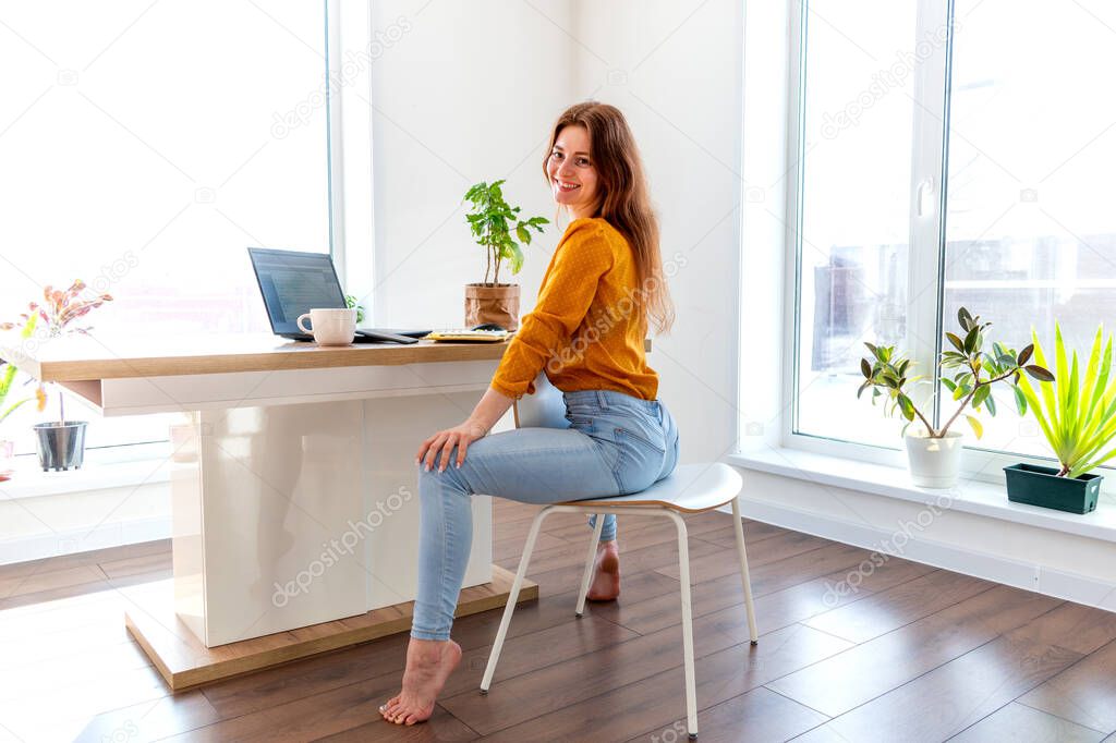 Young business woman is meditating after work the Internet using a computer. Female girl listens to calm music near the laptop. Home comfort zone and mental health concept.