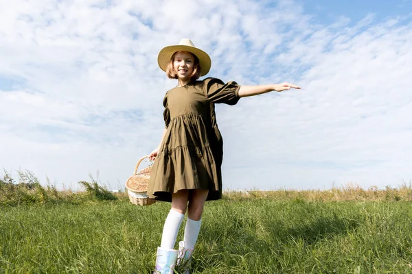 穿着亚麻布衣服和草帽的女孩在花田里跳舞 柳条筐在手 福利和自由概念 青少年的天性 — 图库照片