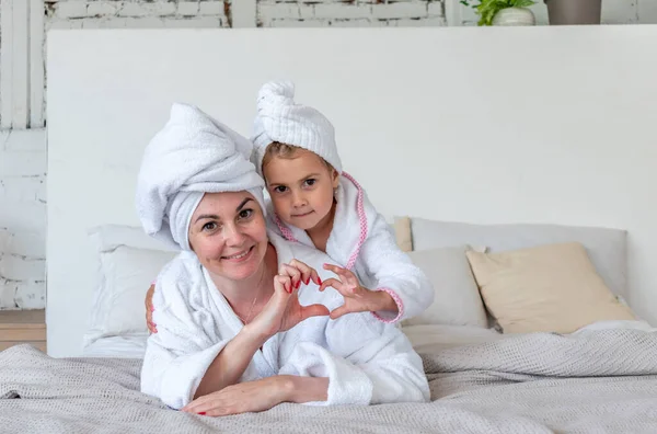 Anne Kızı Beyaz Bornoz Giyip Yatakta Otururken Sarılıyorlar Aile Içinde — Stok fotoğraf