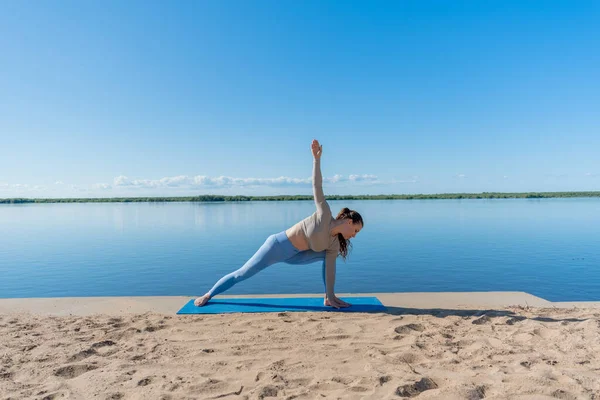 Diversity red hair woman doing yoga outdoors in the park. Sportswear and yoga mat. Wellness and sports lifestyle concept. Copy space