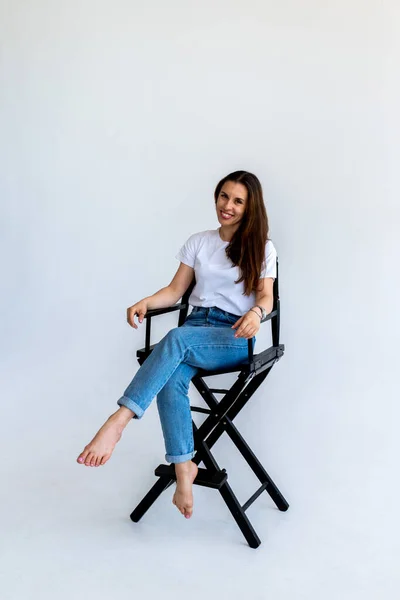 Die Erwachsene Frau Sitzt Blauen Jeans Und Weißem Shirt Auf — Stockfoto