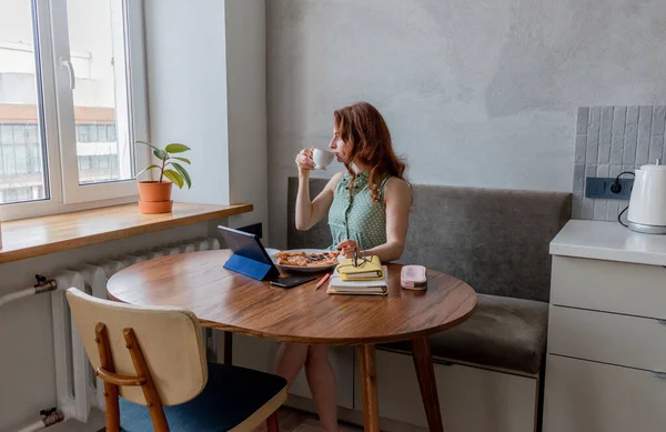 Defoktus. Genç bir kadın öğle yemeği sırasında bilgisayarla eğitimini internetten alıyor. Serbest çalışan bir kadın dizüstü bilgisayarda geziniyor. Aşırı bilgi yüklenmesi kavramı. Teknoloji ve insanlar. Evde Konfor Bölgesi.