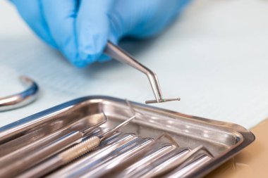 Diş aletleri kapanıyor. Dişçi, matkap için cımbızla matkap tutuyor. Diş tedavisi. makro fotoğrafçılık