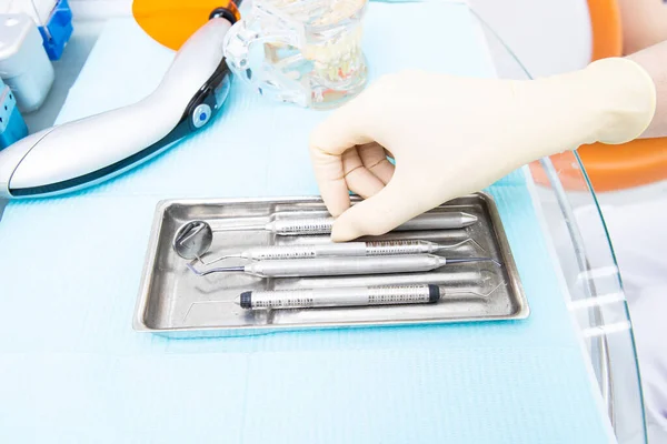 La mano de los dentistas en el guante blanco toma la herramienta de la bandeja con herramientas — Foto de Stock