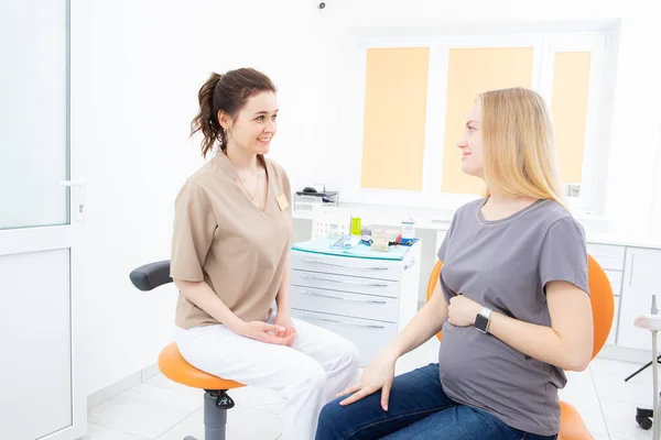 Положительная беременная женщина в кабинете дантиста, консультации с молодой женщиной дантист. лечение зубов беременных женщин — стоковое фото