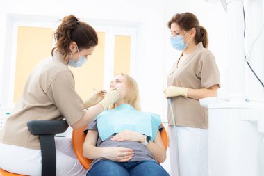 Hamile kadınlar için dişçi muayenehanesindeki hamile kadın, sağlık kontrolü ve diş tedavisi.