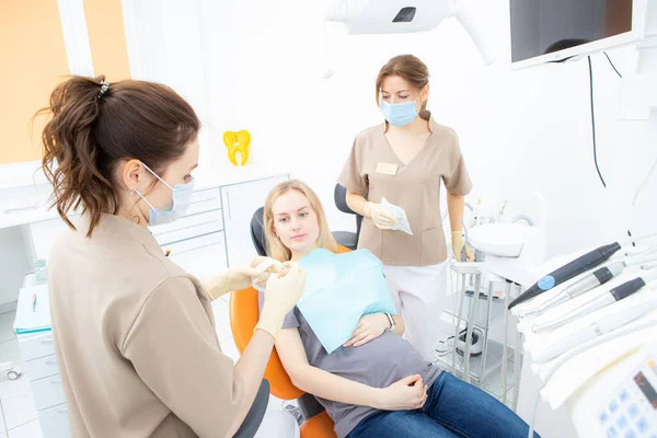 Mulher grávida no consultório de dentistas, check-up e tratamento odontológico para mulheres grávidas. Imagem De Stock