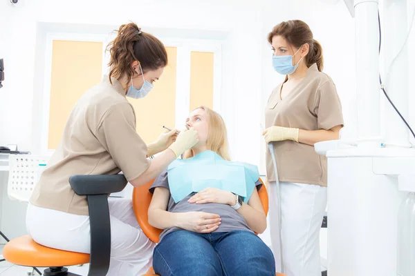 Беременная женщина в кабинете стоматолога, осмотр и стоматологическое лечение беременных женщин. — стоковое фото