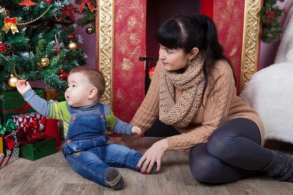 Moeder en zoon in de buurt van de kerstboom. — Stockfoto