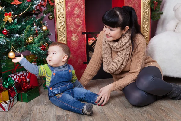 Mother and son  near christmas tree. — Stock Photo, Image