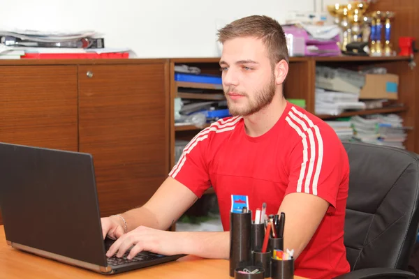 Casual homem trabalhando no escritório, sentado na mesa, digitando no chaveiro — Fotografia de Stock