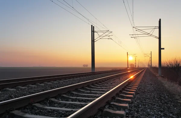 Railroad - Railway at sunset with sun — Stock Photo, Image