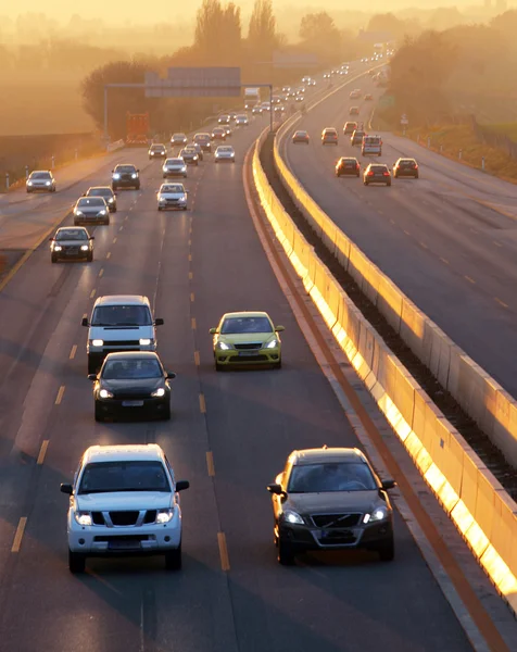 Auto's op snelweg weg bij zonsondergang — Stockfoto