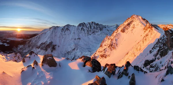 Snowy mountains under orange sunset sky — Stock Photo, Image