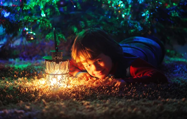 Criança com luz de Natal e árvore — Fotografia de Stock