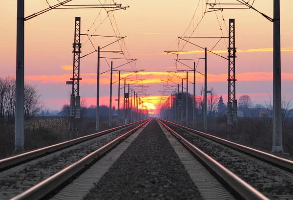 Spoorlijn - spoorweg bij zonsondergang met zon — Stockfoto