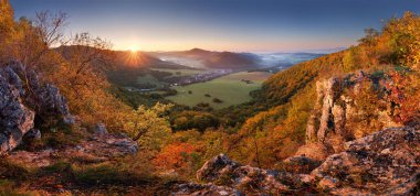 Slovakya 'da altın ormanı ve köyü olan sonbahar dağ manzarası