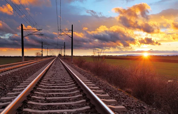 Oranje zonsondergang in lage wolken boven spoorweg — Stockfoto