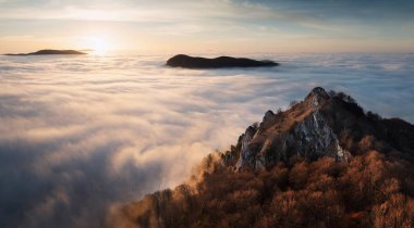 Gün batımında bulutlar, güneş ışınları ve sisli vadiler ormanı, dağı ve doğayı gözler önüne serer..