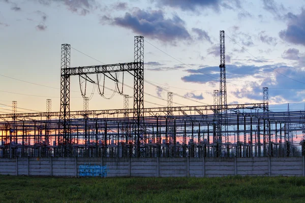 Red en la estación del transformador en la salida del sol, alto voltaje — Foto de Stock
