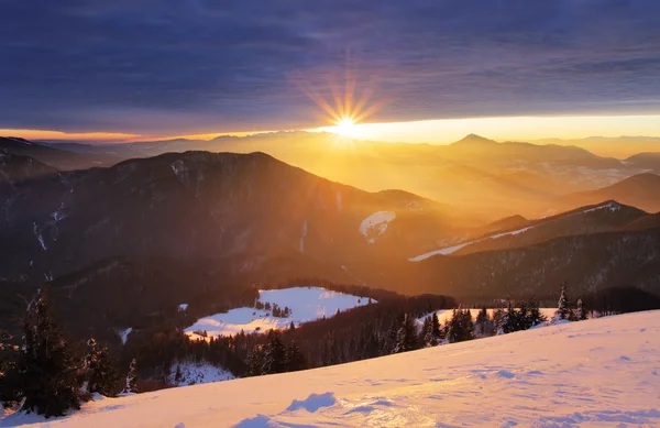 Zonsondergang over kleur berg silhouet met stralen — Stockfoto