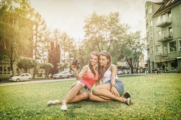 Zwei schöne junge Frauen mit einer Vintage-Kamera — Stockfoto