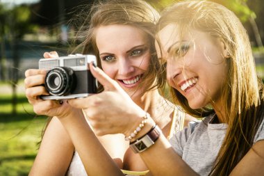 İki güzel genç kadın vintage bir kamera ile