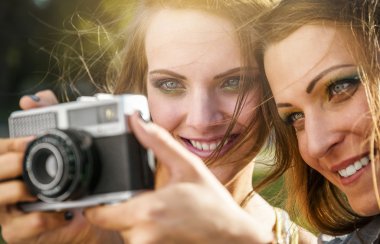İki güzel genç kadın vintage bir kamera ile