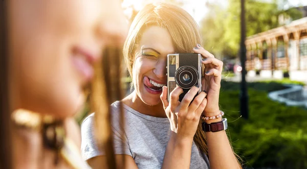 Due belle giovani donne che utilizzano una fotocamera vintage — Foto Stock