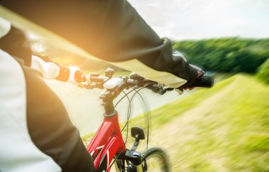 Happy young woman riding a bicycle outside.