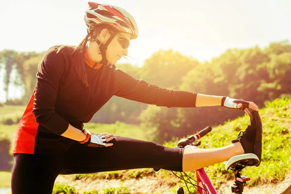 Happy young woman riding a bicycle outside. Stok Resim